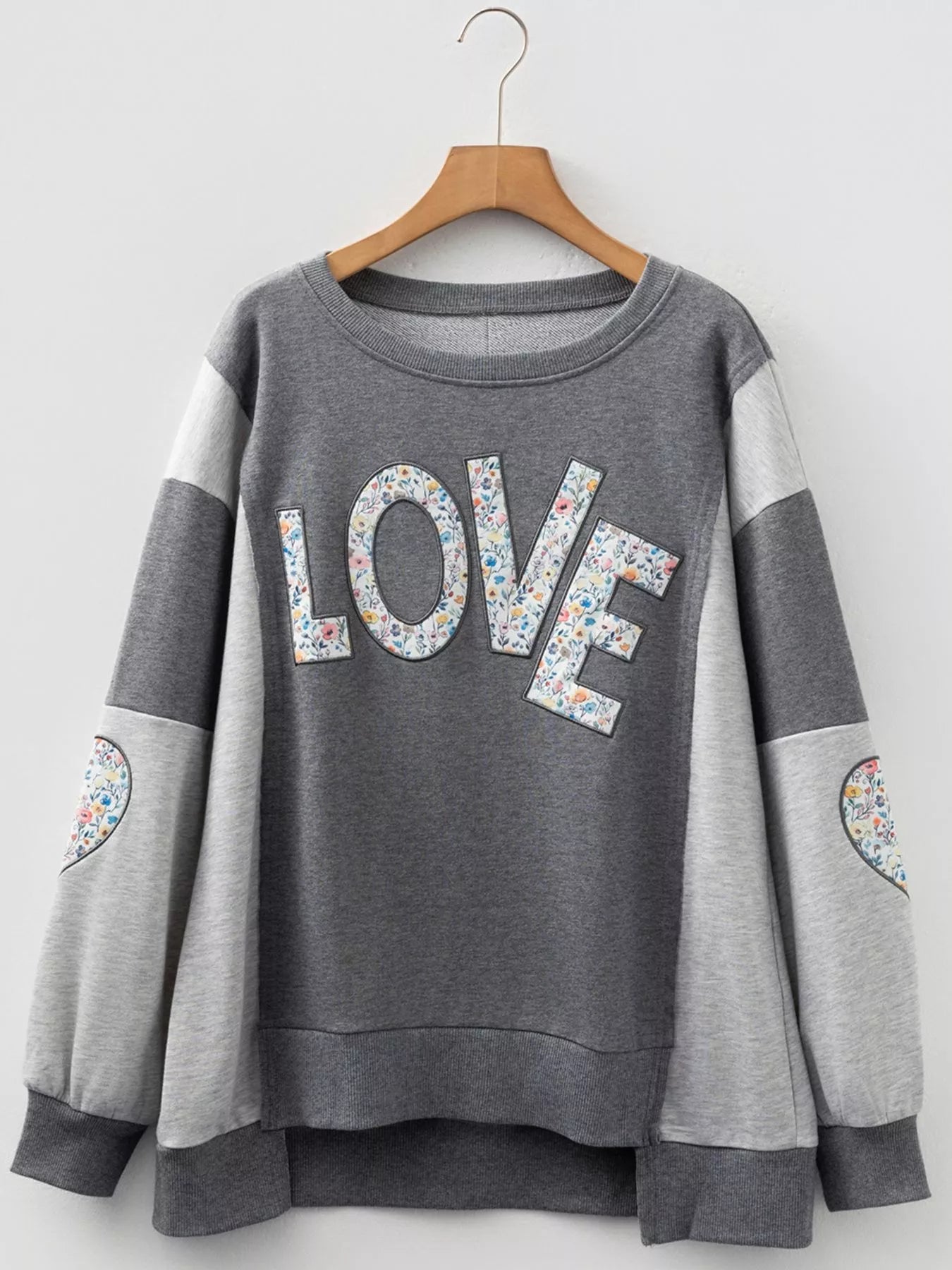 LOVE Graphic Exposed Seam Patchwork Uneven Hem Chic Sweatshirt designed for comfort and style at Lookzlike