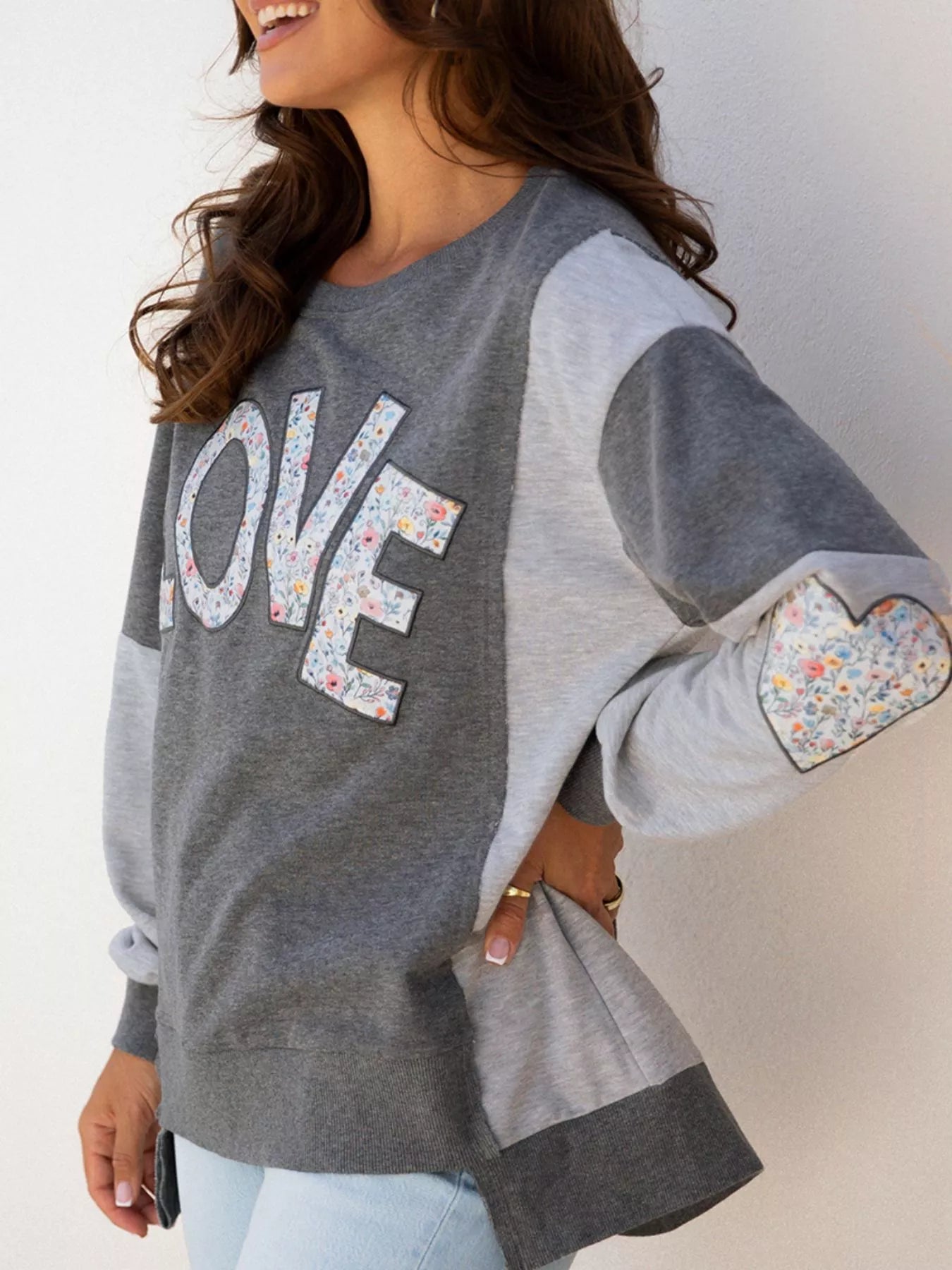 LOVE Graphic Exposed Seam Patchwork Uneven Hem Chic Sweatshirt designed for comfort and style at Lookzlike