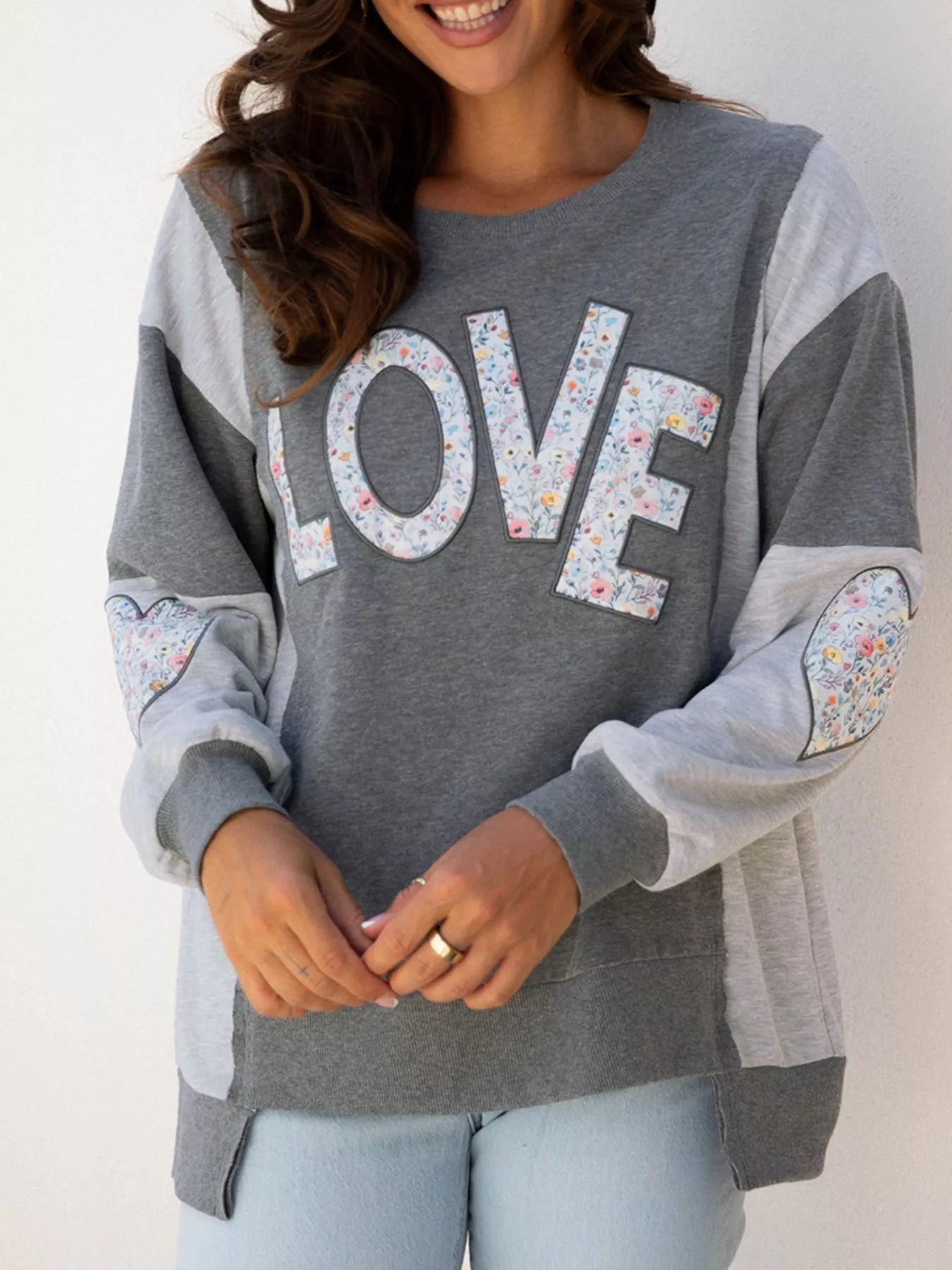 LOVE Graphic Exposed Seam Patchwork Uneven Hem Chic Sweatshirt designed for comfort and style at Lookzlike