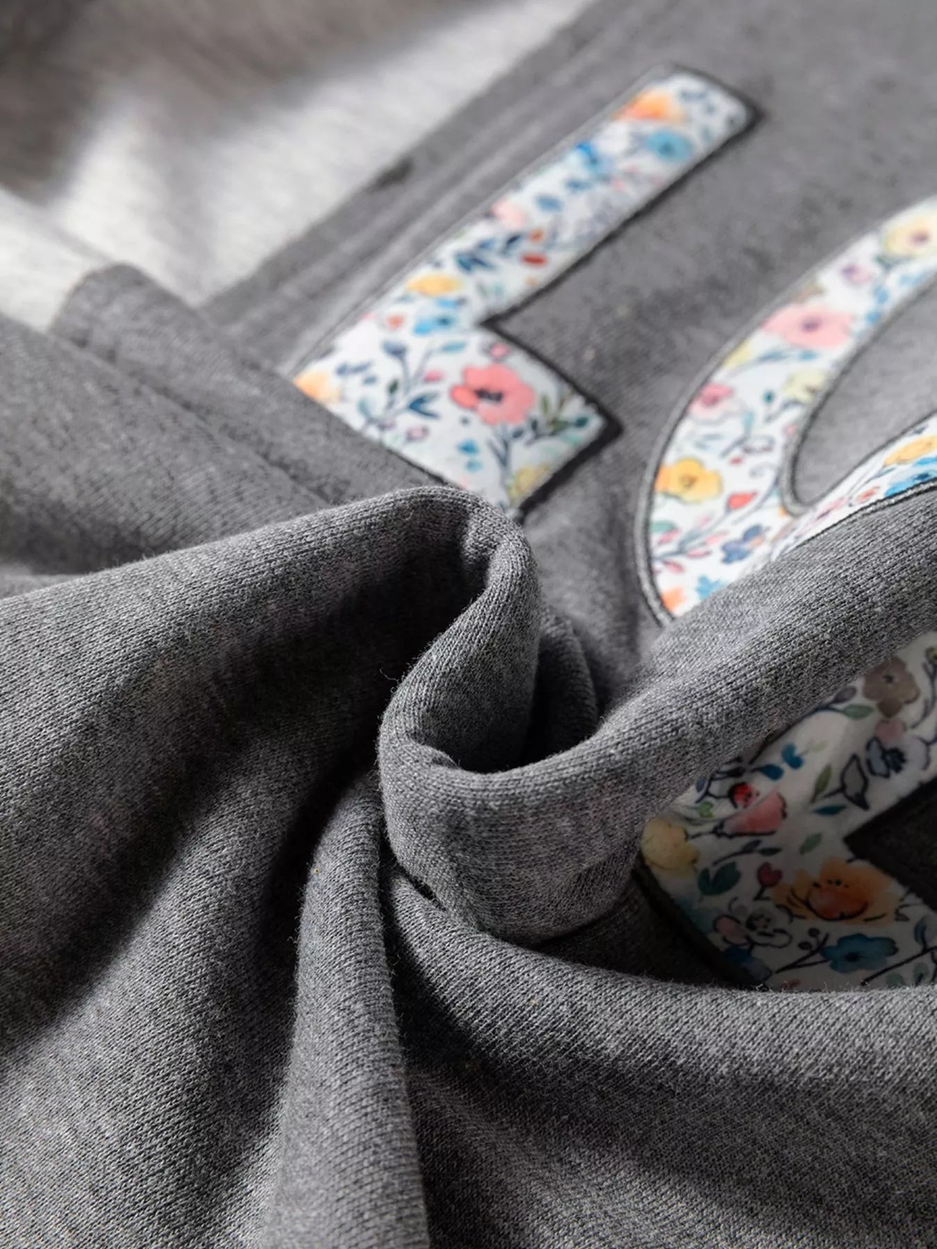 LOVE Graphic Exposed Seam Patchwork Uneven Hem Chic Sweatshirt designed for comfort and style at Lookzlike