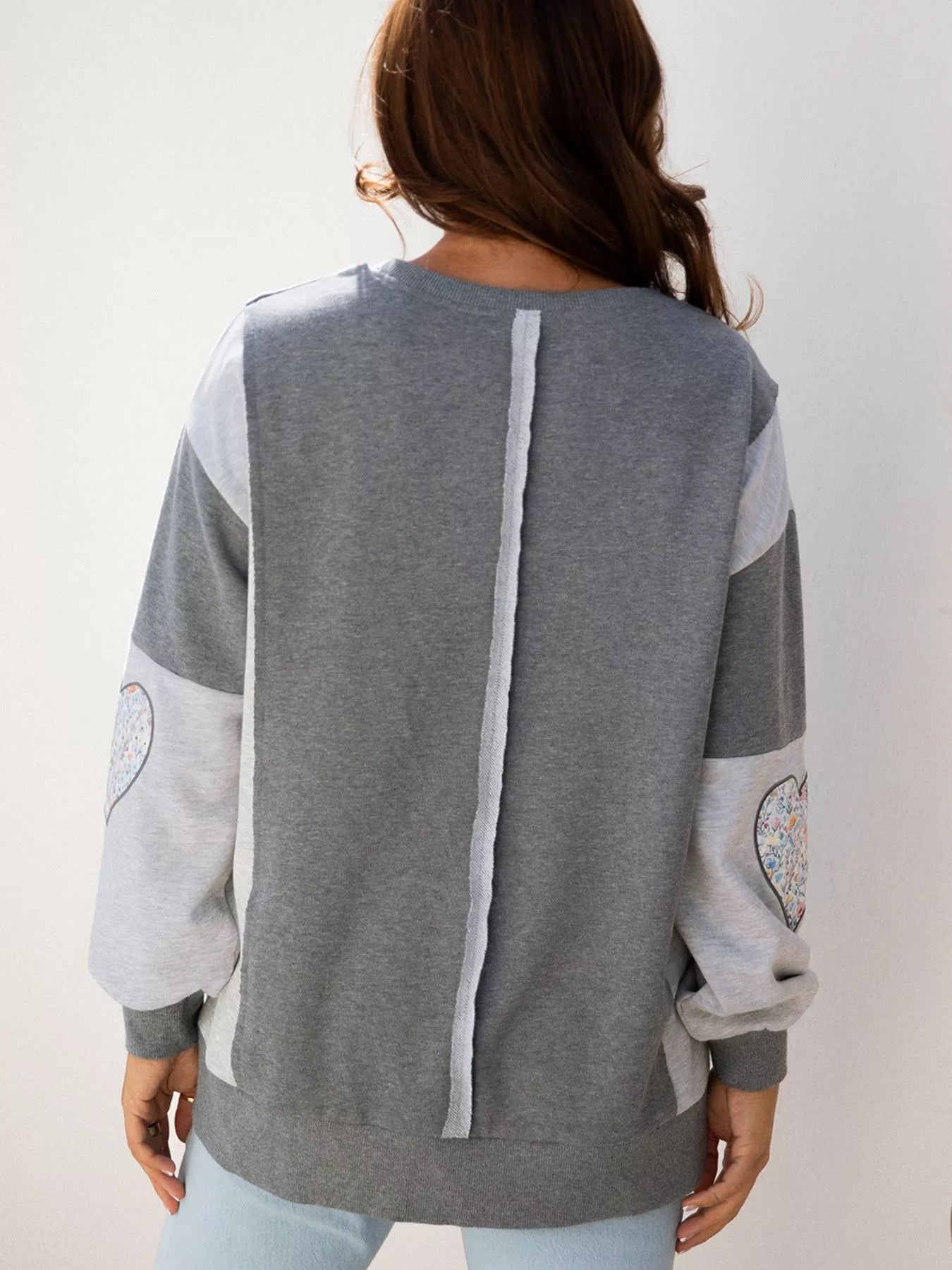 LOVE Graphic Exposed Seam Patchwork Uneven Hem Chic Sweatshirt designed for comfort and style at Lookzlike