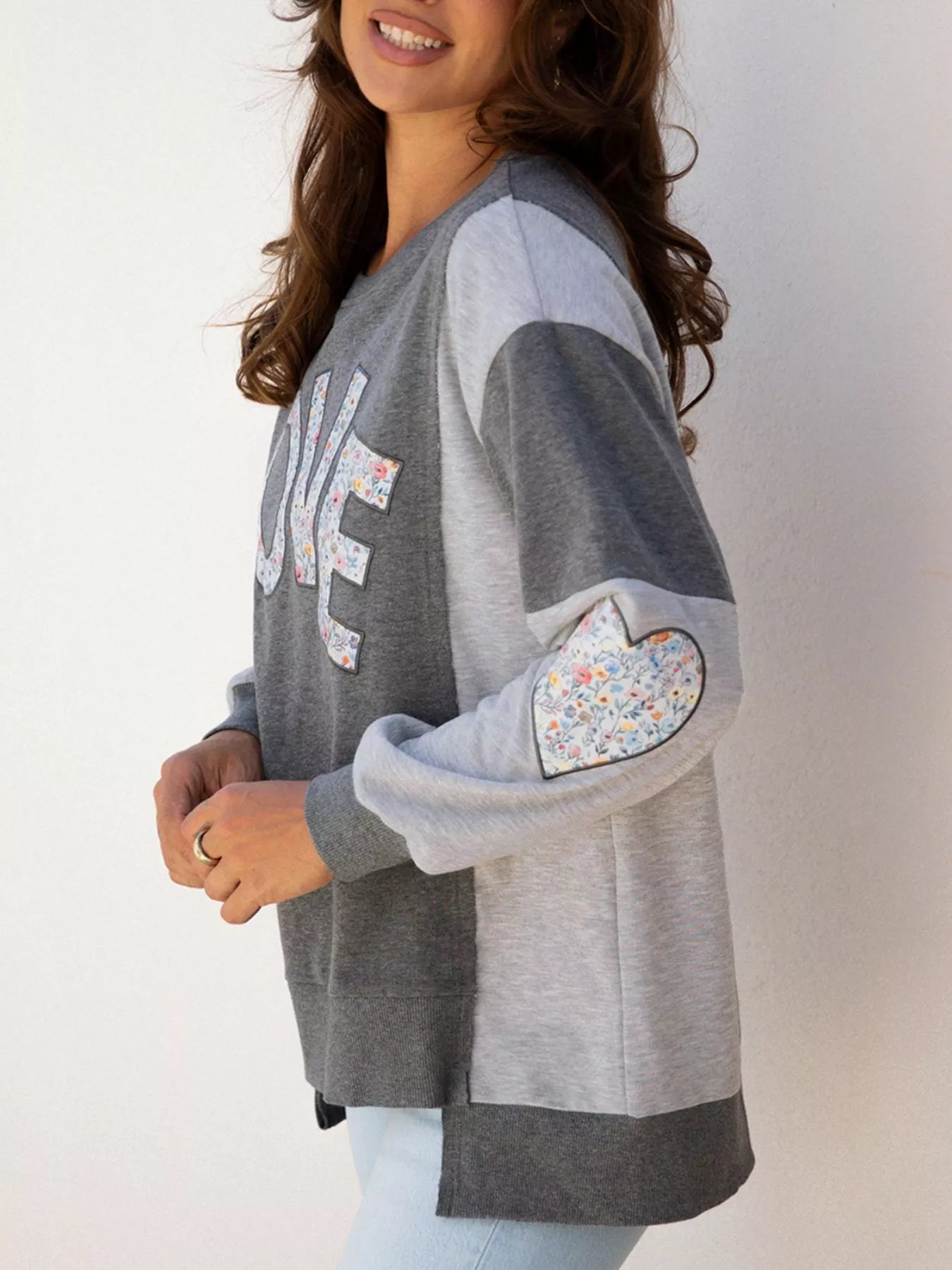 LOVE Graphic Exposed Seam Patchwork Uneven Hem Chic Sweatshirt designed for comfort and style at Lookzlike
